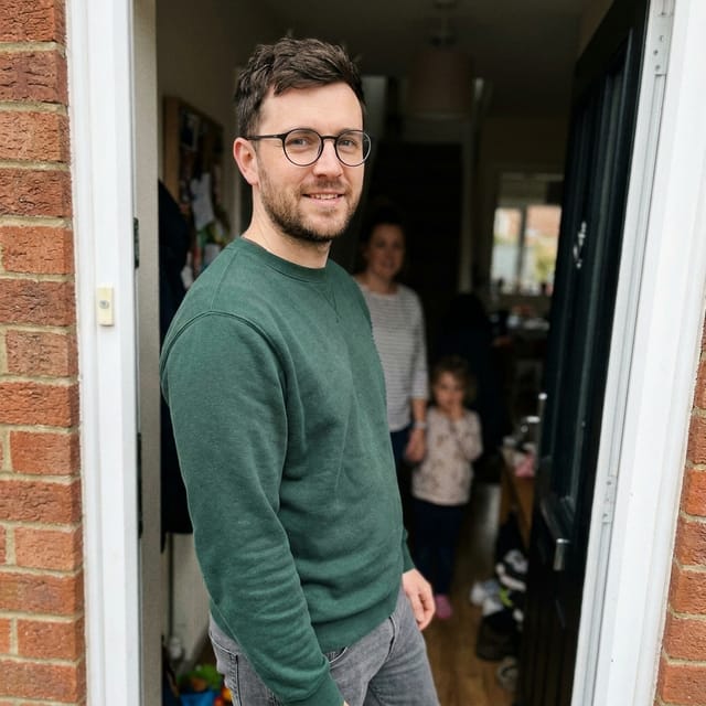 Foto van papa: kort donker haar, baard, ronde bril, groene sweater